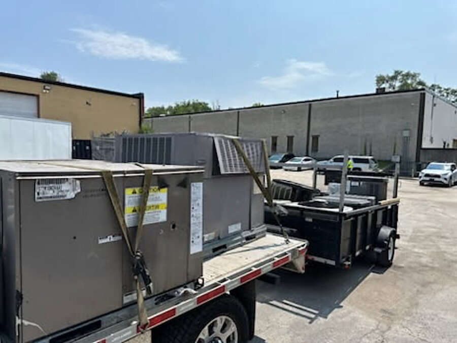 Rooftop HVAC units strapped to a trailer